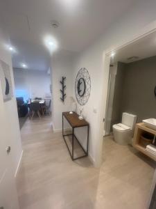 a bathroom with a toilet and a table with a mirror at CONCHEIROS 5 APARTAMENTOS TURISTICOS in Santiago de Compostela