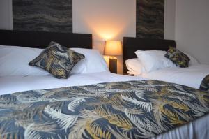 two beds in a hotel room with a blanket at The Corner Rooms at The Black Horse Inn in Spennymoor