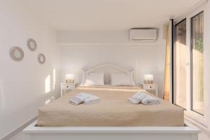 - une chambre blanche avec un grand lit et 2 oreillers dans l'établissement Valentina's apartment, à Pouládes