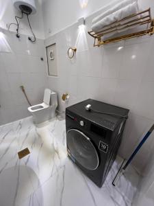 a bathroom with a washing machine and a toilet at كورنيش عجمان in Ajman 