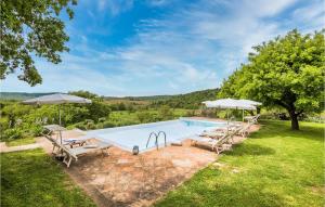 a swimming pool with chairs and umbrellas at 4 Bedroom Beautiful Home In Rapolano Terme Si in Rigomagno
