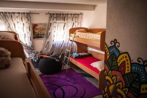Habitación con 2 literas y alfombra morada. en Hostel Backpackers, en Mostar