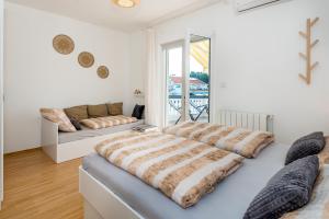 a living room with two beds and a couch at Apartment and Rooms Dalmatiko in Vodice