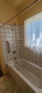 a bathroom with a bath tub and a window at Historic Dow Hotel in Lone Pine