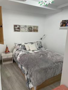 a bedroom with a bed and a white wall at Luminoso Loft en la Ciudad Vieja in A Coruña