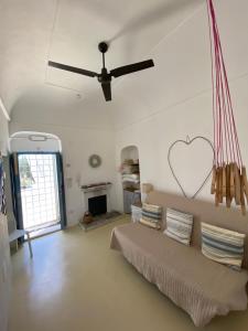 ein Wohnzimmer mit einem Sofa und einem Deckenventilator in der Unterkunft Casa San Valentino in Vico del Gargano