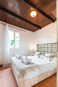 sypialnia z dużym łóżkiem i drewnianym sufitem w obiekcie Casa da Achadinha by Atlantic Holiday w mieście São Jorge