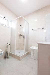 La salle de bains blanche est pourvue d'une douche et de toilettes. dans l'établissement Casa da Achadinha by Atlantic Holiday, à São Jorge