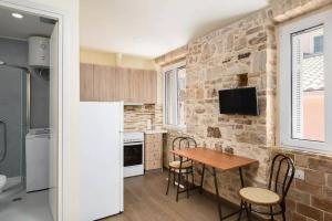 a kitchen with a table and a stone wall at Q Apartments in Corfu Town in Corfu