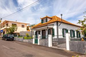 mały biały dom z pomarańczowym dachem w obiekcie Casa da Achadinha by Atlantic Holiday w mieście São Jorge