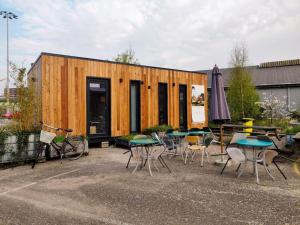 een klein houten gebouw met tafels en stoelen bij tiny house in Rotterdam