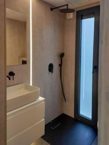 een badkamer met een witte wastafel en een douche bij tiny house in Rotterdam