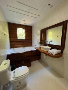 a bathroom with a toilet and a sink and a tub at Pousada Lua e Sol in Estancia do Castello