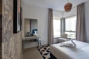 um quarto de hotel com um cisne na cama e uma cadeira em BellaVista 2 BR 29 Boulevard Downtown Burj Khalifa em Dubai