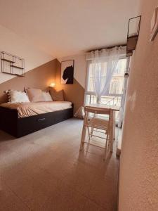 sypialnia z łóżkiem, stołem i oknem w obiekcie Urban Oasis Blancarde w Marsylii