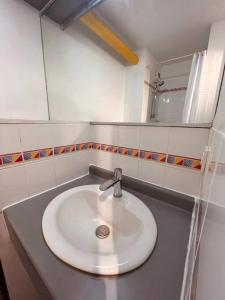 W łazience znajduje się biała umywalka i lustro. w obiekcie Urban Oasis Blancarde w Marsylii