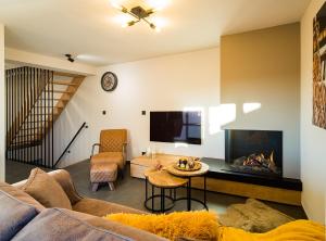 a living room with a couch and a fireplace at Welldone Resort - Cozy Saxofoon in Nieuwerkerken +2 photos