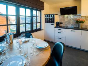 a kitchen with a wooden table with wine glasses on it at Welldone Resort - Cozy Saxofoon in Nieuwerkerken