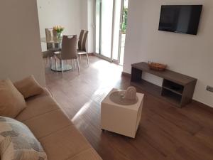 uma sala de estar com um sofá, uma televisão e uma mesa em Apartments Huljić em Hvar