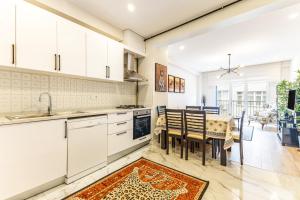 a kitchen with white cabinets and a table and chairs at New Apartment near Nisantasi & Macka Park in Istanbul
