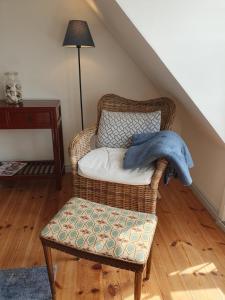 a wicker chair with a blanket on it in a room at Hotel Brummers Anneks in Haderslev