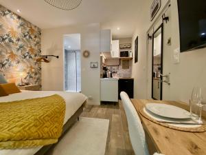 Habitación con cama, mesa y cocina. en ღ Le Maya - Business & Repos à Toulouse * Netflix en Toulouse
