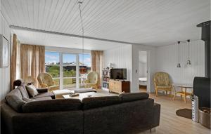 a living room with a couch and a table at Stunning Home In Harbore With House A Panoramic View in Harboør
