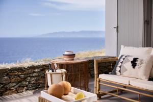 weranda z krzesłem i stołem z widokiem na ocean w obiekcie Ianemi Suites by K4 Kythnos w mieście Kitnos