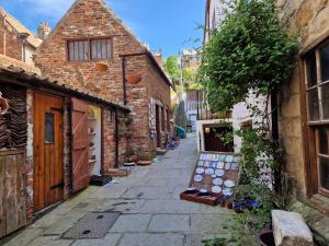 an alley with brick buildings and a bench in a street at Wesley Chapel- Cyanacottages in Whitby