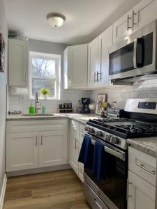 a kitchen with white cabinets and a stove top oven at SJ Suburban HiDeAwAy 