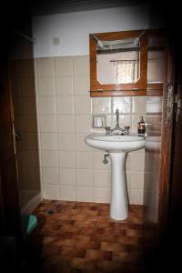 uma casa de banho com um lavatório branco e um espelho. em Nymph em Sálakos