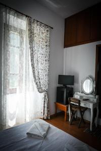 a bedroom with a bed and a desk and a window at Nymph in Sálakos