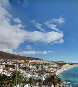 una ciudad en una playa con palmeras y el océano en Apartamento playero Privado WiFi- MorroJable en Morro del Jable