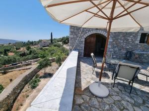 patio con ombrellone, tavolo e sedie di Castle in Oitylo a Oitylo