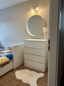 ein Schlafzimmer mit einer weißen Kommode und einem Spiegel in der Unterkunft Warsaw Apartments Wiatraczna in Warschau