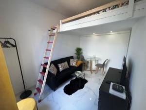 een woonkamer met een bank en een hoogslaper bij Cosy Studio in Bondy 15min from Paris in Bondy