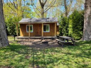 a small wooden cabin with a picnic table and a bench at Tobermory Village Cabins in Tobermory