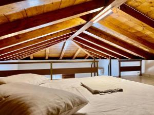 un letto in una stanza con soffitto in legno di Casa Matina by Goutos Luxury Living a Didyma