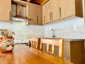 una cucina con tavolo in legno e vaso; di Casa Matina by Goutos Luxury Living a Didyma Altre 28 foto