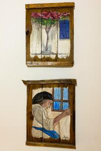 una pintura de una mujer mirando por una ventana en Aegean breeze apartment en Kárpatos