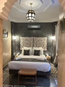 a bedroom with a large bed and a chandelier at Riad Al Nubala in Marrakech