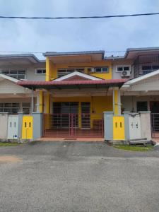 un bâtiment jaune avec une porte devant lui dans l'établissement NVACASTAY, à Marang