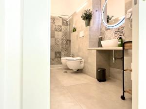 ein Badezimmer mit einem WC, einem Waschbecken und einem Spiegel in der Unterkunft Don Pietro - Pieno Centro Storico in Ostuni