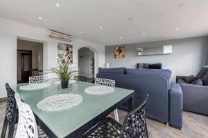 a living room with a table and a blue couch at Aimar Atico duplex Playa la Pineda Port Aventura in La Pineda