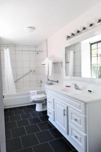 a white bathroom with a tub and a sink and a toilet at Atterdag Inn in Solvang