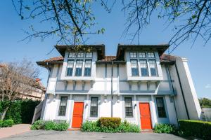 a large white house with orange doors at Atterdag Inn in Solvang