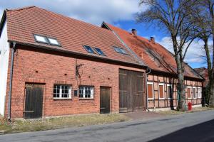 un bâtiment en briques rouges avec des portes et un toit rouge dans l'établissement Sternstunden, à Breetz