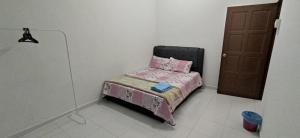 a small bed in a room with a door at NVACASTAY in Marang