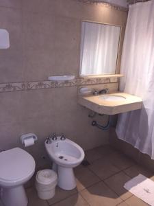 uma casa de banho com um lavatório, um WC e um espelho. em Centro Plaza Hotel em Concordia