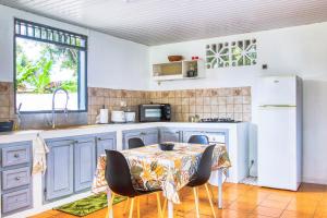 uma cozinha com uma mesa com cadeiras e um frigorífico em Résidence Sapotille em Matoury